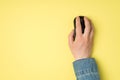 First person top view photo of female hand with black computer wireless mouse on isolated yellow background with copyspace Royalty Free Stock Photo