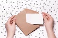 First person top view photo of female hands holding open craft envelope with white card, Receive mail Royalty Free Stock Photo