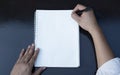 First person top view photo of male hands in black pullover writing in spiral notepad Royalty Free Stock Photo