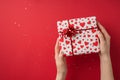 First person top view photo of valentine`s day decor glitter girl`s hands demonstrating gift box in white wrapping paper with