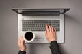 First person top view photo of woman`s hands typing on laptop keyboard and holding cup of coffee on isolated grey background Royalty Free Stock Photo