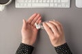 First person top view photo of woman`s hands using sanitizer transparent bottle white keyboard mouse and cup of coffee on isolate Royalty Free Stock Photo