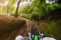 First person view of a man riding a rollercoaster cart in jungles. Motion blurred