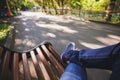 First-person view a man sitting on wooden bench in the park. Royalty Free Stock Photo