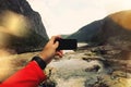 First-person view, the man takes a photo of a mountain river on smartfon. Concept, black screen smartphone Royalty Free Stock Photo