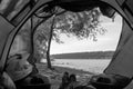 First-person view from the tent. The concept of travel and camping on a motorcycle in the wild. Riverbank, bonfire and motobike.