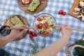 First person view of Woman mix vegan salad on picnic outside. Vegan food concept Royalty Free Stock Photo