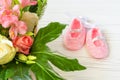 First pink shoes for little princess. Baby shoes with a basket with bright flowers.