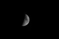 First quarter moon over dark black sky seen with a telescope Royalty Free Stock Photo