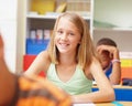 First-rate education for outstanding individuals. Confident young elementary school girl sitting at her desk in class