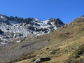 First snow on the rocky mountain peak Chilbiritzenspitz (2852 m) in the Albula Alps and above the alpine valley