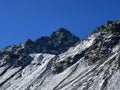 First snow on the rocky mountain peak Schwarzhorn (3147 m) in the Albula Alps and above the mountain road pass Fluela Royalty Free Stock Photo