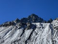First snow on the rocky mountain peak Schwarzhorn (3147 m) in the Albula Alps and above the mountain road pass Fluela Royalty Free Stock Photo