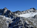 First snow on the rocky mountain peaks Piz Sarsura Pitschen (3132 m) and Piz Sarsura (3176 m) Royalty Free Stock Photo