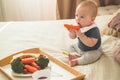 First solid food for young kid. Fresh organic carrot for vegetable lunch. Baby weaning.