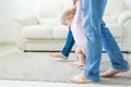 First steps of baby toddler learning to walk in white sunny living room. Footwear for child. Royalty Free Stock Photo