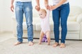 First steps of baby toddler learning to walk in white sunny living room. Footwear for child. Royalty Free Stock Photo