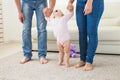 First steps of baby toddler learning to walk in white sunny living room. Royalty Free Stock Photo