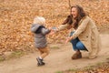 First steps. Cute little boy run to his mother in the autumn park. Happy mom and child playing together outdoors. Family, Royalty Free Stock Photo