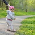 The first steps of the kid. Little baby girl walks in park