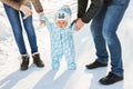 First steps. Little baby learning to walk. Mother and father with toddler boy at the winter park Royalty Free Stock Photo