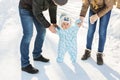 First steps. Little baby learning to walk. Mother and father with toddler boy at the winter park Royalty Free Stock Photo