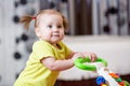 First steps of little girl in baby walker Royalty Free Stock Photo