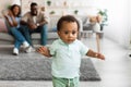 Cute baby toddler walking in living room making first steps Royalty Free Stock Photo