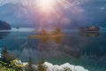 First sun rays on the mountain lake Eibsee in Bavarian Alps. sunrise over mountains and small island with reflection