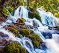 First sunlight lights up the pure water waterfall on Plitvice National Park. Colorful spring scene of green forest with blue lake. Royalty Free Stock Photo