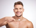 First thing to do in the morning. Studio shot of a young man brushing his teeth against a grey background. Royalty Free Stock Photo