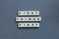 ' First Things First ' word made of square letter word on grey background Royalty Free Stock Photo