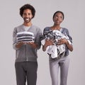 First timers luck. Studio shot of a man holding a neatly folded pile of clothes while his partners is in a mess.