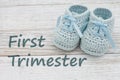 First Trimester message with blue baby booties Royalty Free Stock Photo