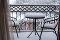 The first white fluffy snow on the table and chairs on the wrought-iron balcony. Fabulous winter