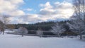 After the first winter snowfall, snow lies on the banks of the river, on benches and on tree branches. One of the banks is concret Royalty Free Stock Photo