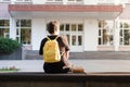 First year student sitting outside a university or school facility. Freshman waiting for the beginning of the classes Royalty Free Stock Photo
