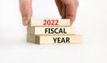 2022 fiscal new year symbol. Concept words `2022 fiscal year` on wooden blocks. Businessman hand. Beautiful white background. Co