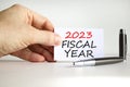 2023 fiscal year symbol. White paper with words 2023 Fiscal year. Businessman hand. Metallic pen. white table white