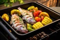 fish in basket on an electric grill with vegetables Royalty Free Stock Photo