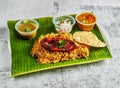 fish biryani rice pulao with salad, chutney, raita and sauce served in dish isolated on banana leaf top view of indian and Royalty Free Stock Photo