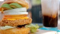 Fish burger in breading served with refreshing drink or iced coffee at beachside cafe.