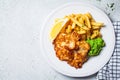 Fish and chips. Cod fish in batter with french fries and mashed peas on a white plate, gray background. English food concept Royalty Free Stock Photo