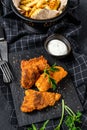 Fish and chips, French fries and cod fillet fried in breadcrumbs. Black background. Top view Royalty Free Stock Photo