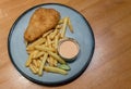 Fish and chips with french fries - unhealthy food. Portion of crispy breaded fish fillet with french fries served on plate . Royalty Free Stock Photo