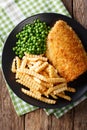 Fish and chips with green peas close-up on a plate. Vertical top Royalty Free Stock Photo