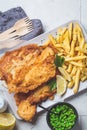 Fish and chips with green peas on gray tile background. British cuisine concept Royalty Free Stock Photo