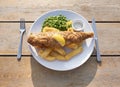 Fish, chips and peas on table, british takeaway food. Royalty Free Stock Photo