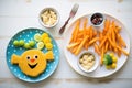 fish and chips portioned for kids with smiley face potatoes Royalty Free Stock Photo