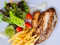 fish and chips steak grill serving with french fries and salad white sauce. hot salmon and cod seafood in white circle plate Royalty Free Stock Photo